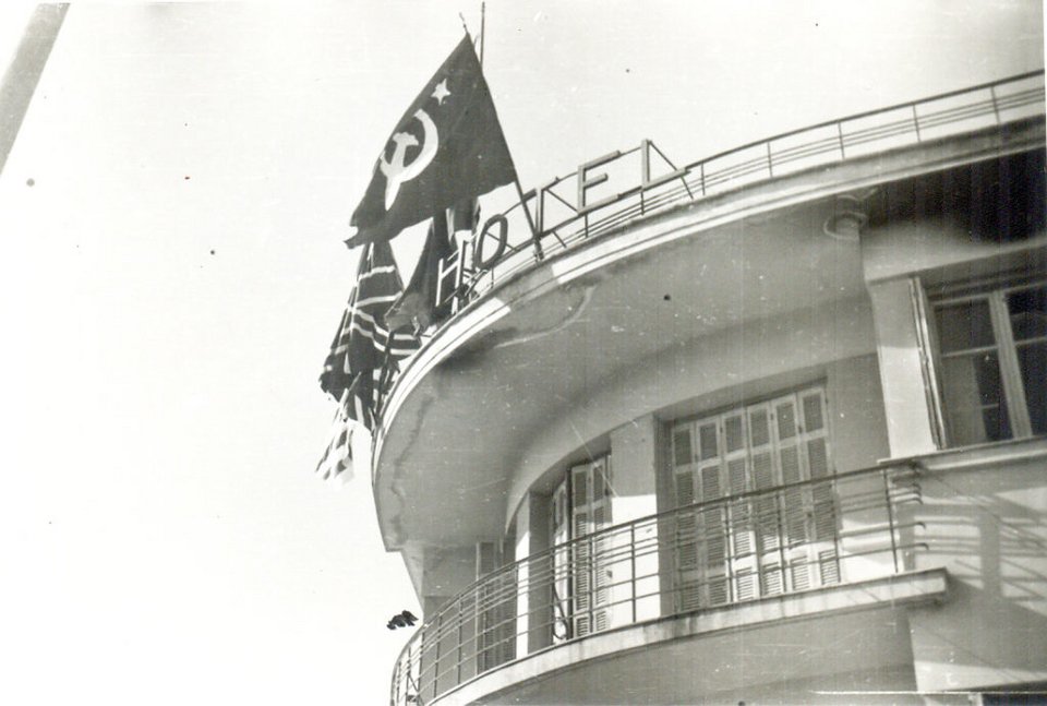 Στον τελευταίο όροφο του ξενοδοχείου Ακροπόλ ήταν τοποθετημένες στα κάγκελα τέσσερις σημαίες, μια Ρωσική (σφυροδρέπανο), μια Αγγλική μια Ελληνική και μια Αμερικανική που μόλις διακρίνεται.
