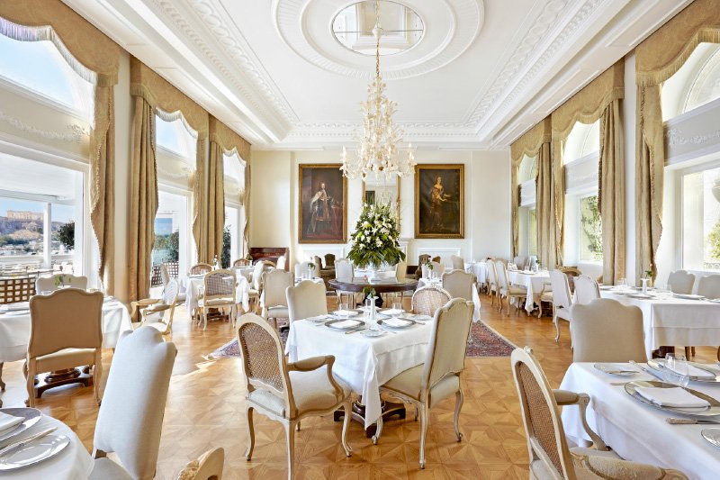 Tudor Hall, Η περίτεχνη σάλα του αριστοκρατικού εστιατορίου σε ύφος μπαρόκ και η βεράντα με το εκπληκτικό κάδρο του Παρθενώνα είναι η σκηνή δράσης για την ελληνική κουζίνα υψηλών προδιαγραφών του Αλέξανδρου Κοσκινά