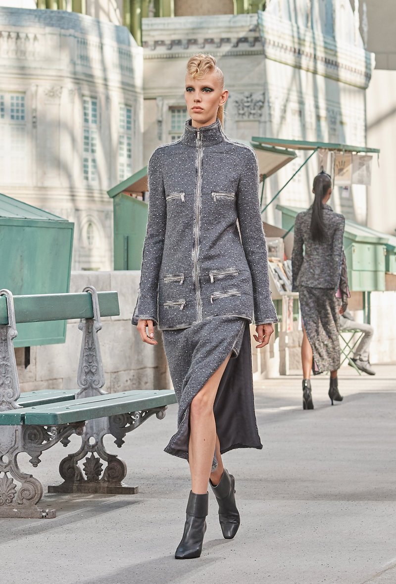 Στο κλασικό  Chanel ταγιέρ η φούστα ανοίγει στο πλάι για να αποκαλύψει μια άλλη, πιο κοντή.