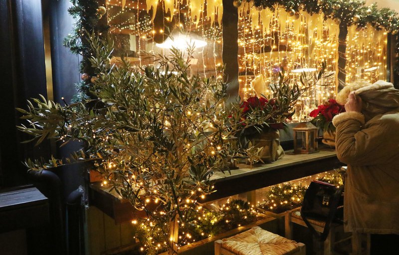 Περαστικοί κοιτούν στολισμό αλλά προϊόντα