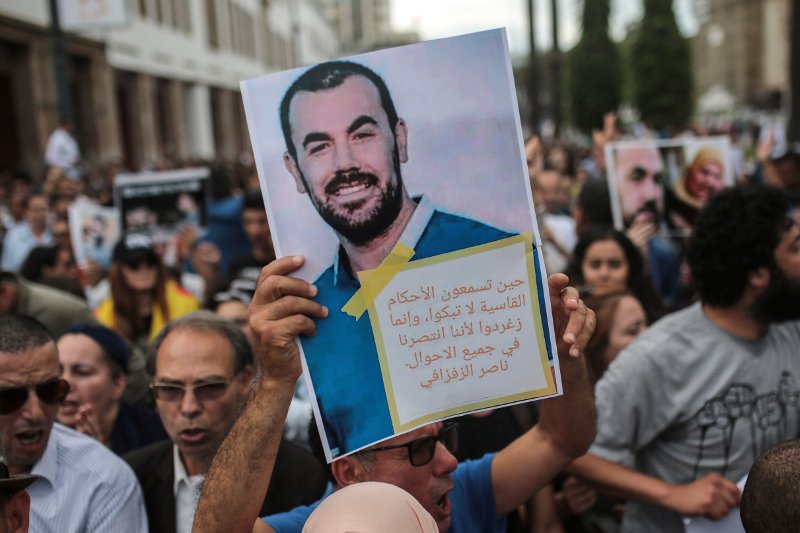 O Nasser Zefzafi εικονίζεται στην αφίσα που κρατούν Μαροκινοί διαδηλωτές οι οποίοι ζητούν την απελευθέρωσή του/Φωτογραφία: ΑΡ