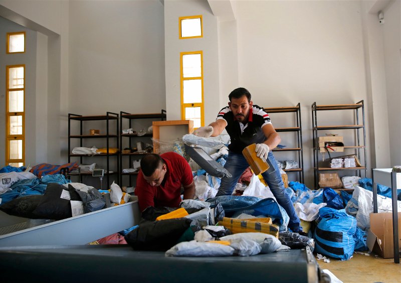 Παλαιστίνιοι υπάλληλοι εργάζονται πυρετωδώς για να ταξινομήσουν τα γράμματα του ταχυδρομείου/Φωτογραφία: AP/Nasser Shiyoukhi