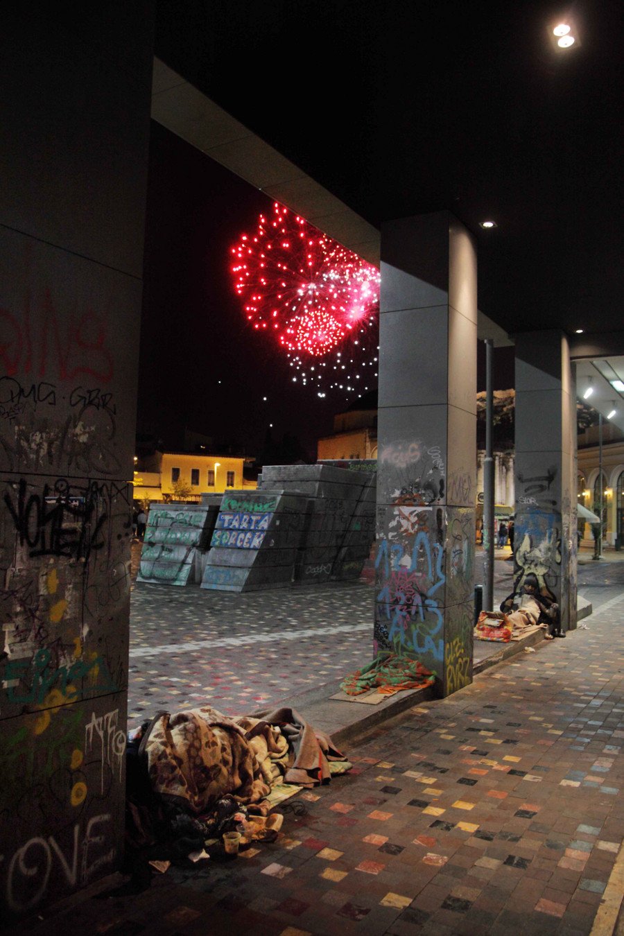 Οι άστεγοι της Αθήνας ξαπλωμένοι, σκεπασμένοι με κουβέρτες στο πεζοδρόμιο κάτω από τα πυροτεχνήματα της Πρωτοχρονιάς [εικόνες] | iefimerida.gr 1