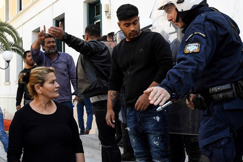 Οι συγγενείς του θύματος με έναν αστυνομικό έξω από το δικαστήριο
