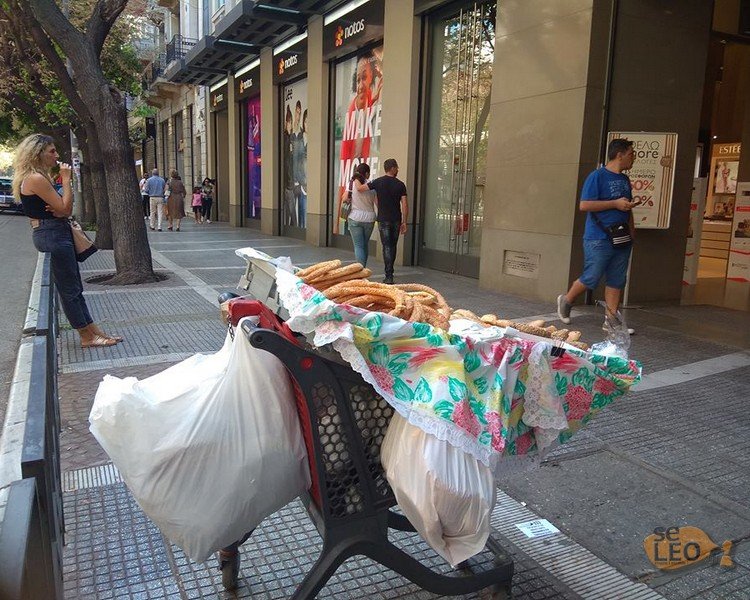 Στο καρότσι υπάρχουν λευκά και πολύσπορα κουλούρια και ψωμάκια