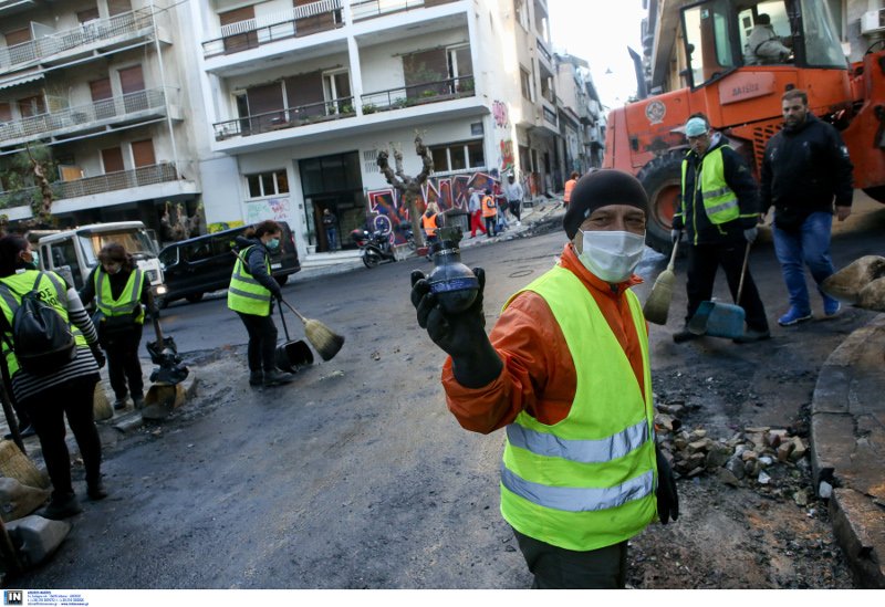 Ανδρας των συνεργείων καθαριότητας δείχνει μία από τις οβίδες κρότου λάμψης που χρησιμοποίησαν τα ΜΑΤ- φωτογραφία intimenews
