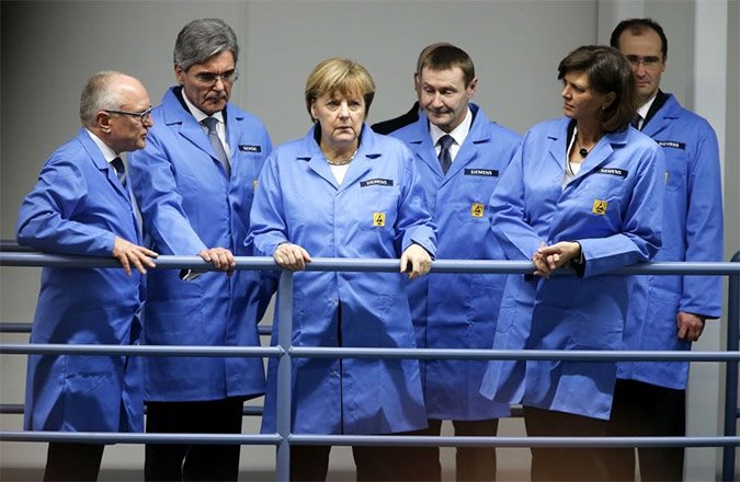 H Μέρκελ με γαλάζιο ρομπάκι, ντύθηκε «εργάτρια» [εικόνες] | iefimerida.gr 8