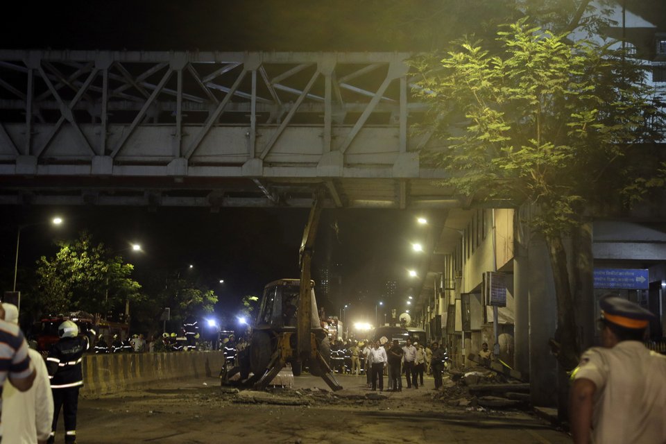 Εκσκαφέας απομακρύνει τα συντρίμμια (AP Photo/Rajanish Kakade)