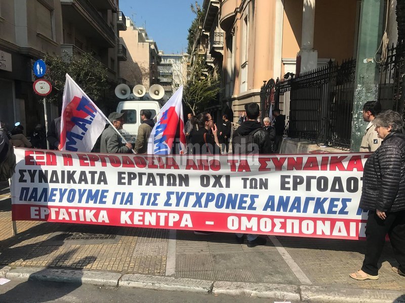 Τα μέλη του ΠΑΜΕ κρατούν πανό και σημαίες