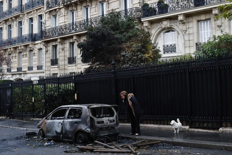 Κάτοικος του Παρισιού μπροστά σε καμμένο αυτοκίνητο