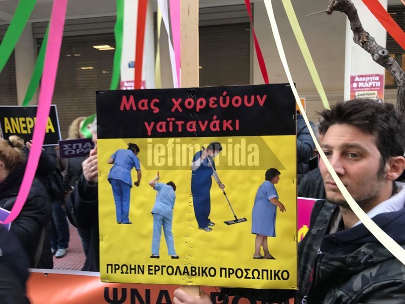 Κρατούν πλακάτ με τις λέξεις «ομηρία», «ανεργία», «ψηφοθηρία», «απολύσεις», «εργασιακός μεσαίωνας», «σπαστά ωράρια»
