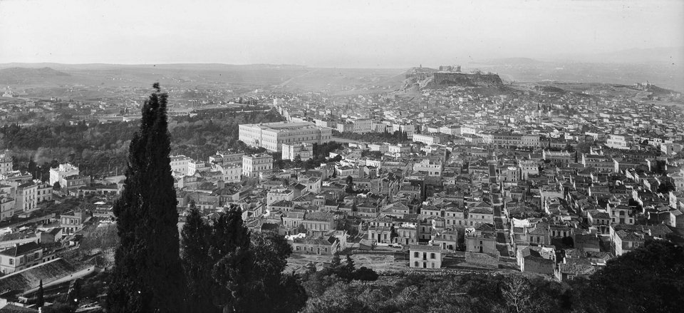 Άποψη της Αθήνας από τους πρόποδες του Λυκαβηττού. Διακρίνονται τα Παλαιά Ανάκτορα με την πλατεία Συντάγματος και την Ακρόπολη στο βάθος. Αριστερά η λεωφόρος Βασ. Σοφίας με τα νεοκλασικά μέγαρα. Σε πρώτο πλάνο η περιοχή του Κολωνακίου με διακριτή την οδό Βουκουρεστίου. Λίγο πριν την κατάληξή της, στα δεξιά, το Ιλίου Μέλαθρον