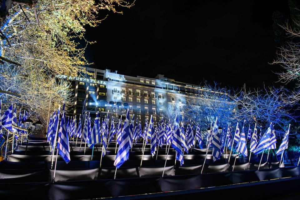 Τη σύνθεση δημιούργησαν οι γεωπόνοι και οι τεχνικοί του Δήμου Αθηναίων και περιστοιχίζεται από ειδικά φωτιζόμενες εξέδρες με 200 σημαίες, μία για κάθε έτος μετά την Επανάσταση.