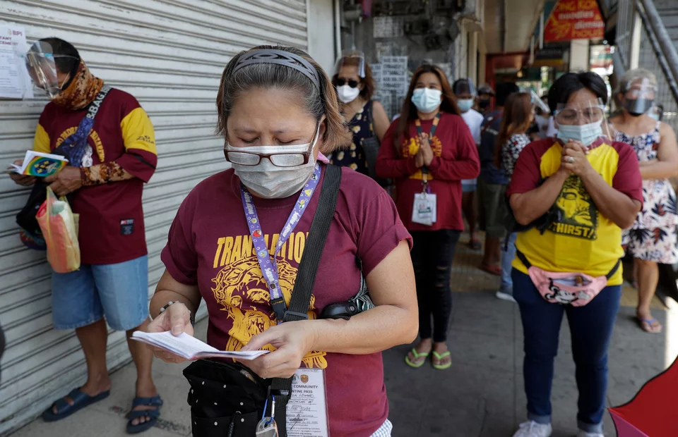 Πιστοί με μάσκες προσεύχονται έξω από ναό ανήμερα της Μεγάλης Παρασκευής στη Μανίλα