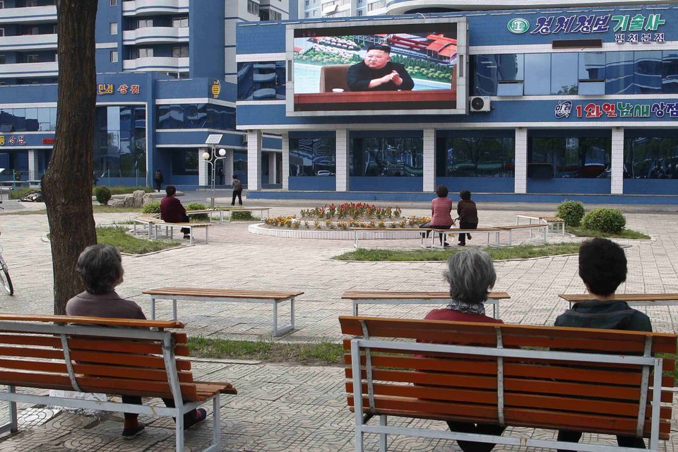 Κόσμος παρακολουθεί καθισμένος σε παγκάκια ομιλία Κιμ Γιονγκ Ουν