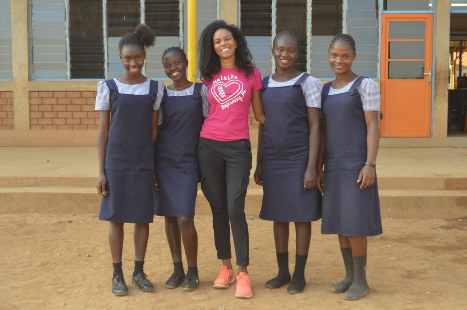 Η Noella ποζάρει χαμογελαστή με μαθήτριες