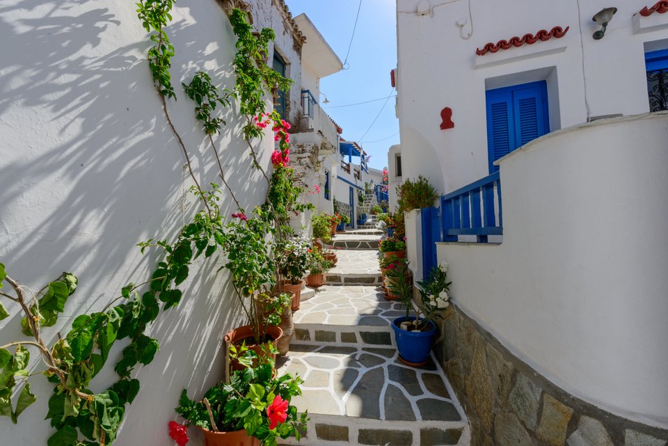 Χαρακτηριστικό σοκάκι με ασβεστολιθικά σπίτια και βουκαμβίλιες στην Κύθνο.