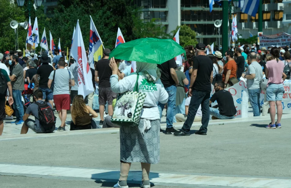 Η κυρία με τη φανέλα του ΠΑΣΟΚ -Στέκεται διακριτικά πίσω από τους συγκεντρωμένους του ΠΑΜΕ