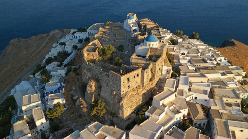 Αεροφωτογραφία του μεσαιωνικού οχυρωμένου κάστρου με θέα το απέραντο γαλάζιο του Αιγαίου στη Χώρα της Αστυπάλαιας κατά το ηλιοβασίλεμα.