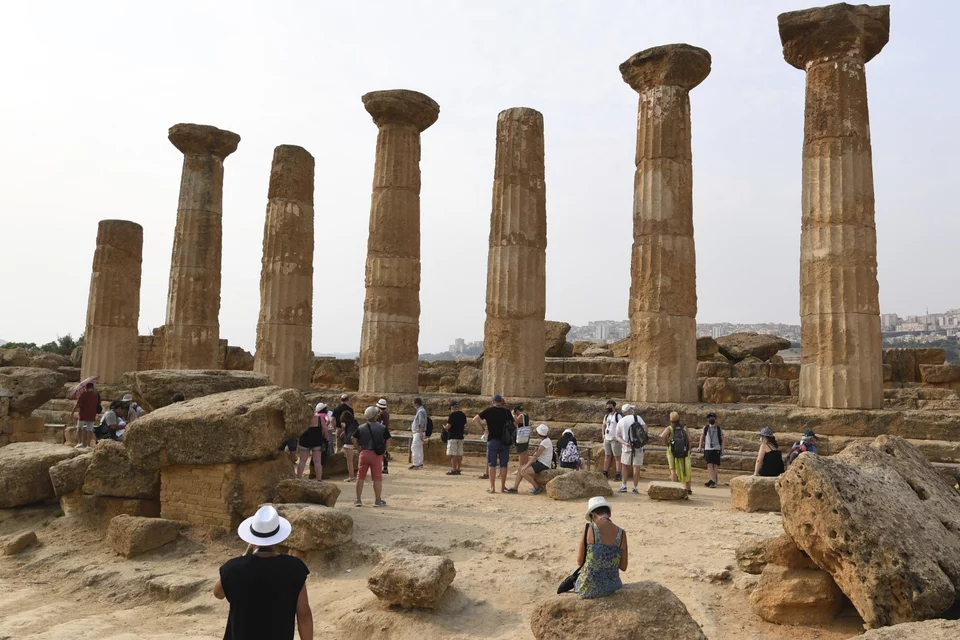 Τουρίστες σε αρχαίο ναό στο Αγκριτζέντο της Σικελίας / Φωτογραφία: AP Photo/Salvatore Cavalli