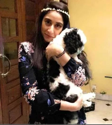 Η Νουρ Μουκαντάμ κρατά αγκαλιά ένα σκυλάκι