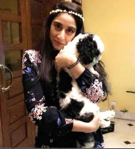 Η Νουρ Μουκαντάμ κρατά αγκαλιά ένα σκυλάκι