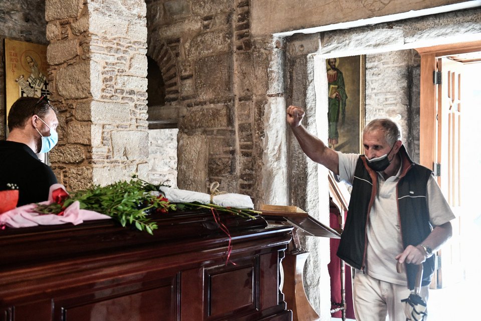 Ένας άνδρας υψώνει τη γροθιά, αποχαιρετώντας έτσι τον Μίκη Θεοδωράκη
