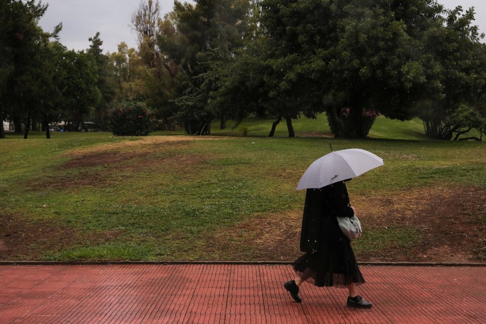 Γυναίκα με ομπρέλα εν μέσω βροχής στην Αθήνα / Φωτογραφία: George Vitsaras-SOOC