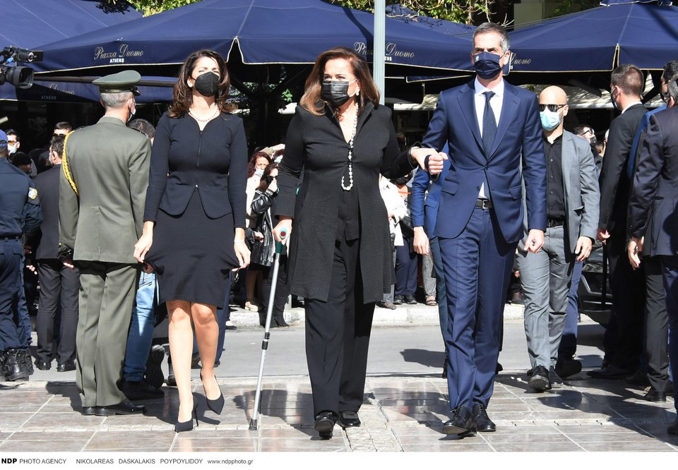 Η Ντόρα Μπακογιάννη υποβασταζόμενη από τον γιο της Κώστα, και συνοδευόμενη από την κόρη της, Αλεξία