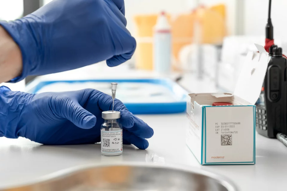 Γιατρός κρατά εμβόλιο Moderna mRNA σε κέντρο εμβολιασμού