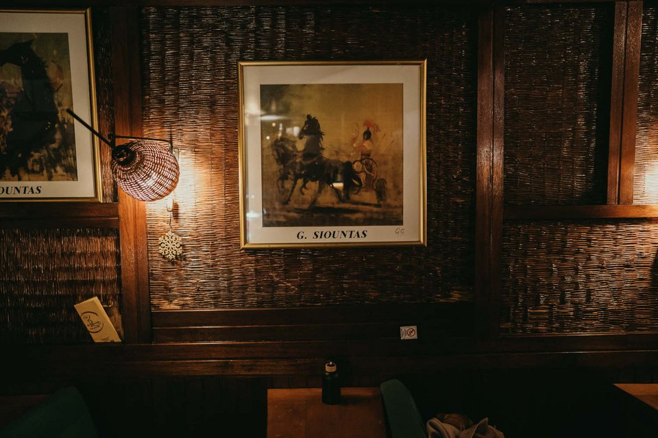 Οι τοίχοι του Au Revoir φιλοξενούν επίσης κάδρα με έργα του εικαστικού Γιώργου Σιούντα