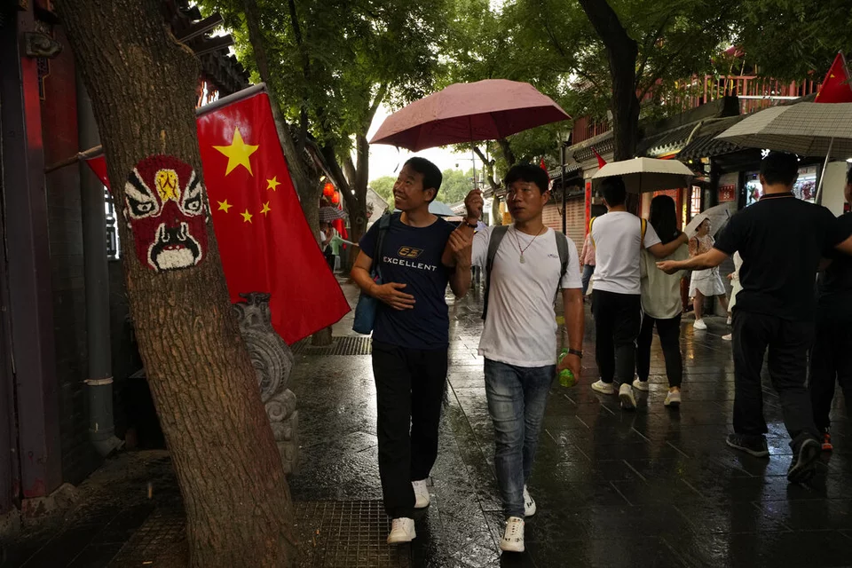 περαστικοί στην Κίνα και δίπλα οι κινεζική σημαία