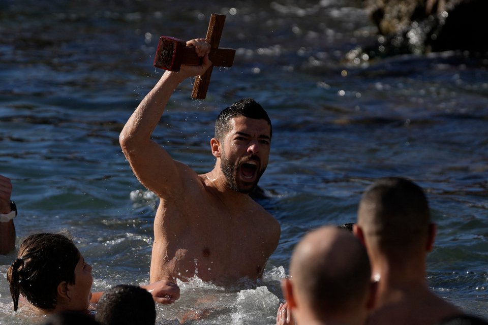 Έπιασε τον Σταυρό κατά τη διάρκεια τελετής ευλογίας του νερού για τους εορτασμούς των Θεοφανείων στο λιμάνι του Πειραιά/ AP Photo/Thanassis Stavrakis