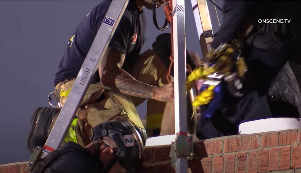 Στη φωτογραφία διακρίνονται τα πόδια της γυναίκας, την ώρα που την τραβούν οι πυροσβέστες για να τη βγάλουν