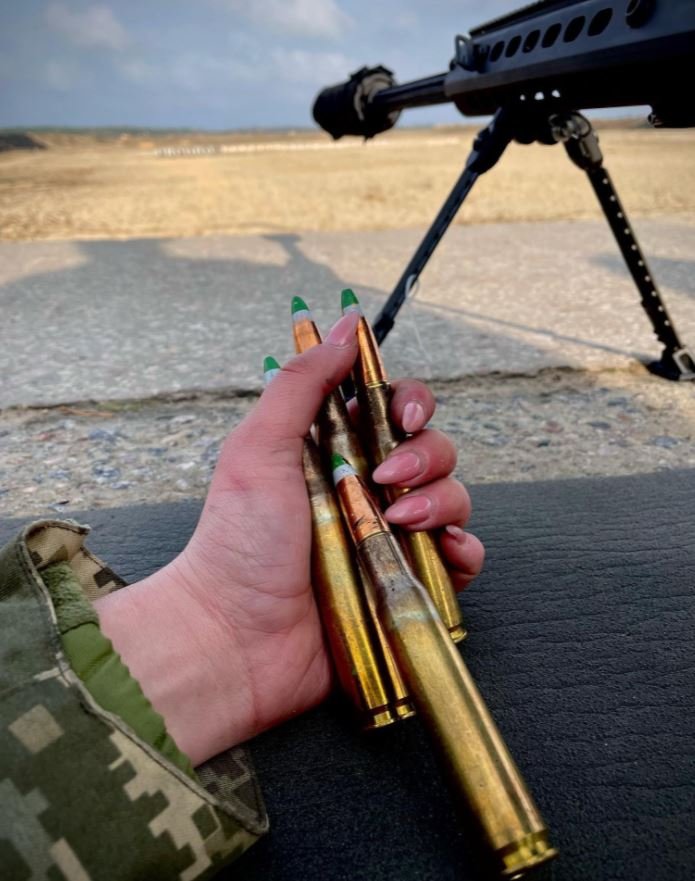 Μια γυναίκα στρατιώτης κρατά πυρομαχικά στο περιποιημένο χέρι της