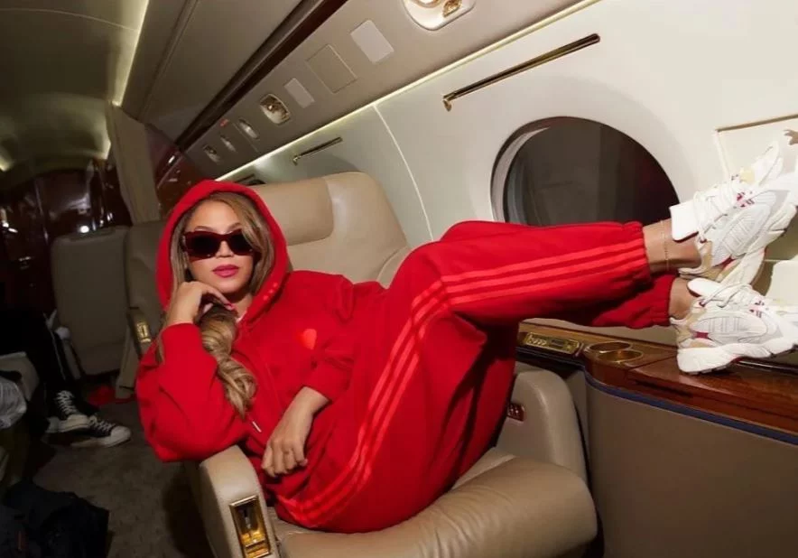 Η Μπιγιονσέ με κόκκινη φόρμα καθιστή χαλαρά