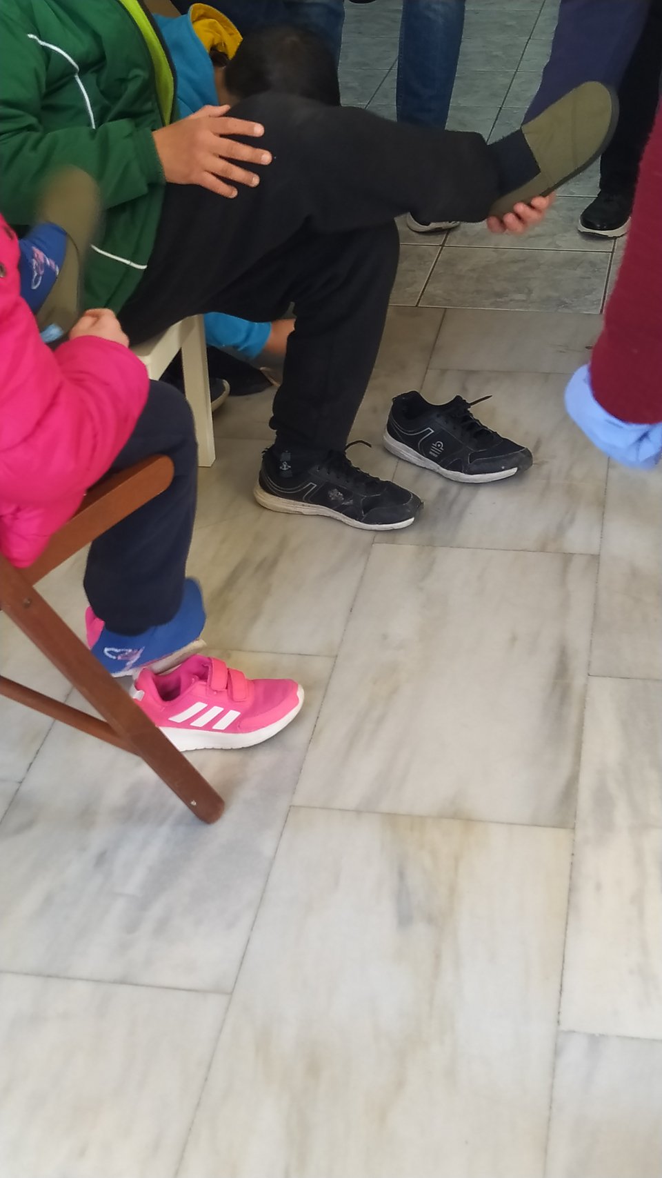 παιδί δοκιμάζει παπούτσια