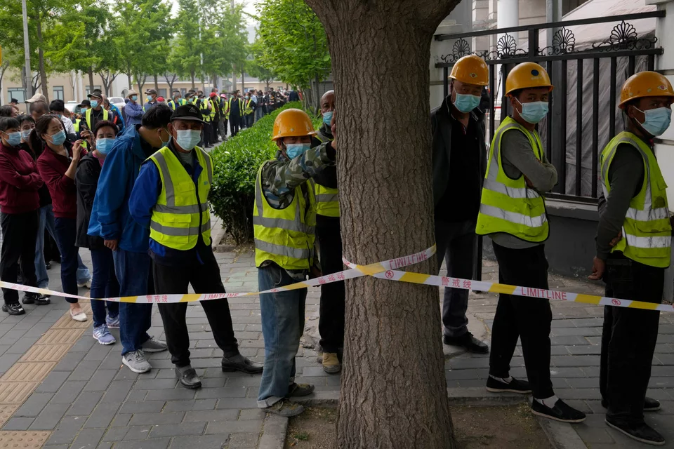 Εργάτες σχηματίζουν ουρά για τεστ κορωνοϊού, στο Πεκίνο