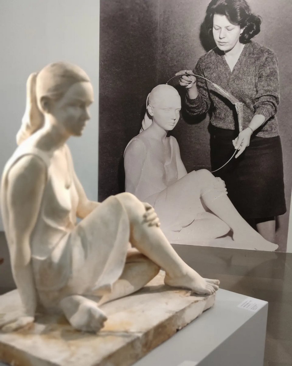 Μπροστά το «Καθιστό κορίτσι» και στο βάθος φωτογραφία της Κατερίνας Χαλεπά καθώς δημιουργεί το γλυπτό / iefimerida