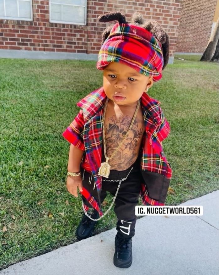 το μόλις ενός έτους αγοράκι με τατουάζ στο στήθος και κοσμήματα