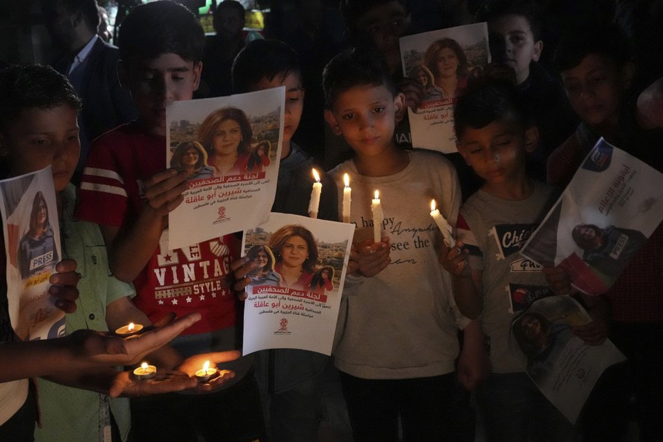 Παιδιά κρατούν αναμμένα κεριά και φωτογραφίες στη μνήμη της δημοσιογράφου/ Φωτογραφία: AP/ Adel Hana