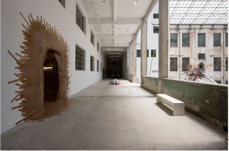 Αριστερά, με τις ταινίες στον τοίχο, η είσοδος στην σπηλιά, το συγκλονιστικό έργο του Τhomas Hirschhorn. Στο βάθος το έργο της Μαρίας Λοϊζίδου «Trauma/war» / Ναταλία Τσουκαλά