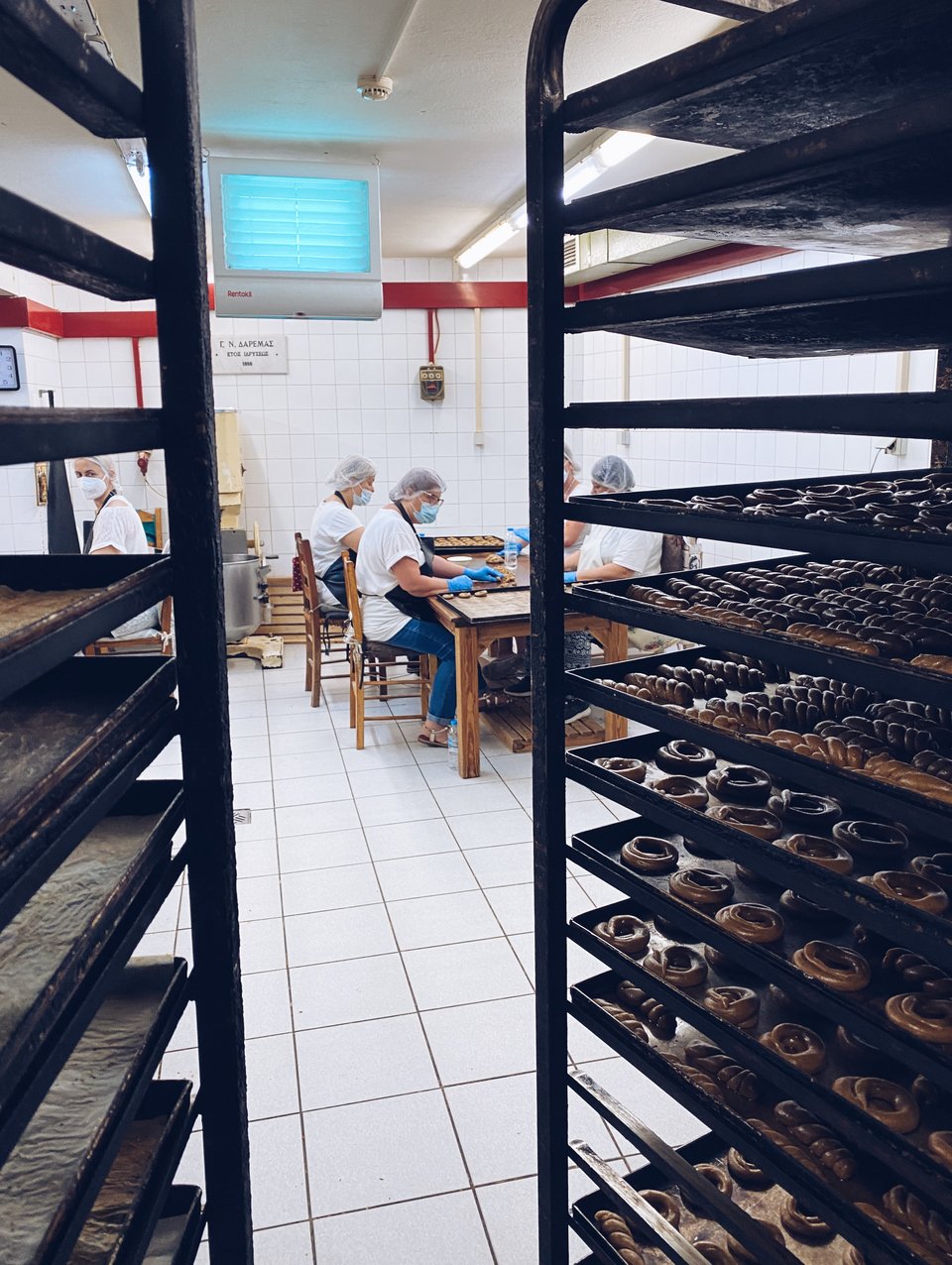 Οι γυναίκες που πλάθουν με τα χέρια τα κουλουράκια στο εργαστήριο. 