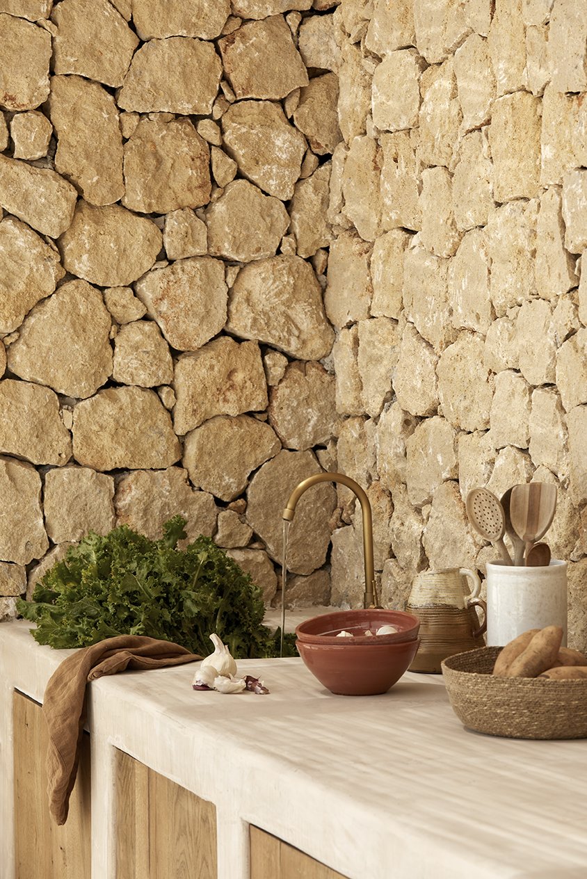 Η open-air κουζίνα είναι επενδυμένη με πατητή τσιμεντοκονία. Μια υπέροχη συνύπαρξη με την πέτρα του τοίχου - Φωτογραφία: Μυρτώ Ιατροπούλου / Courtesy of L Architects