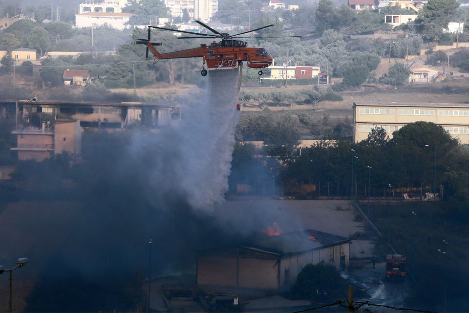 Ελικόπτερο επιχειρεί πάνω από φλεγόμενη αποθήκη 