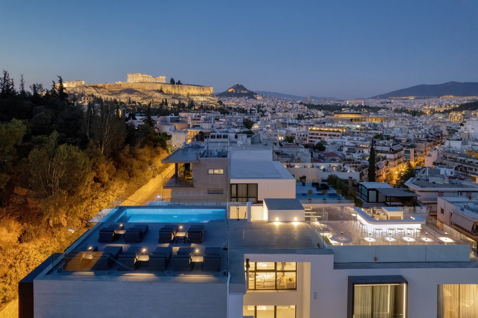Οι φωτισμένες γειτονιές του κέντρου και το roof top του ξενοδοχείου Neoma όπως φαίνονται από το λόφο του Φιλοπάππου.