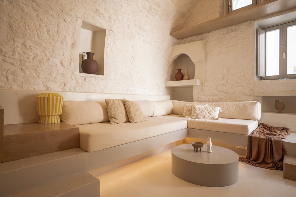 Μοντέρνα design βάζα έχουν τοποθετηθεί στις παλιές πέτρινες εσοχές, εκεί όπου κάποτε οι νησιώτες έβαζαν τα πιθάρια με το νερό ή τις ελιές και το λάδι / Φωτογραφία: DNE Architects