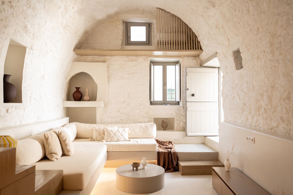 Χτιστοί καναπέδες με αναπαυτικά μαξιλάρια εξοικονομούν τετραγωνικά στο παραδοσιακό θολάρι, δημιουργώντας ένα άνετο και μοντέρνο καθιστικό / Φωτογραφία: DNE Architects