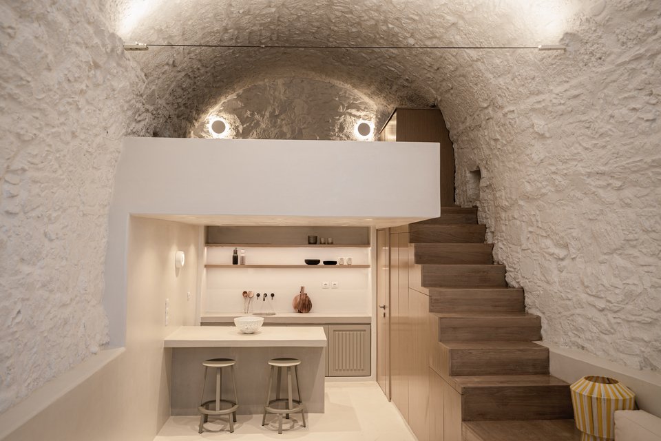 Μια ξύλινη σκάλα οδηγεί στο πατάρι που χρησιμοποιείται ως υπνοδωμάτιο / Φωτογραφία: DNE Architects