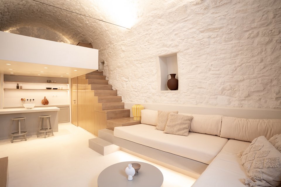 Τα σποτ που φωτίζουν τη θολωτή οροφή αλλά και ο κρυφός φωτισμός κάτω από τους χτιστούς καναπέδες αναπαράγουν το λευκό των τοίχων, δημιουργώντας ευεξία / Φωτογραφία: DNE Architects